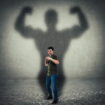 man showing muscles with large stronger shadow behind him