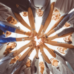 Business people in a huddle with their hands touching in the shape of a heart