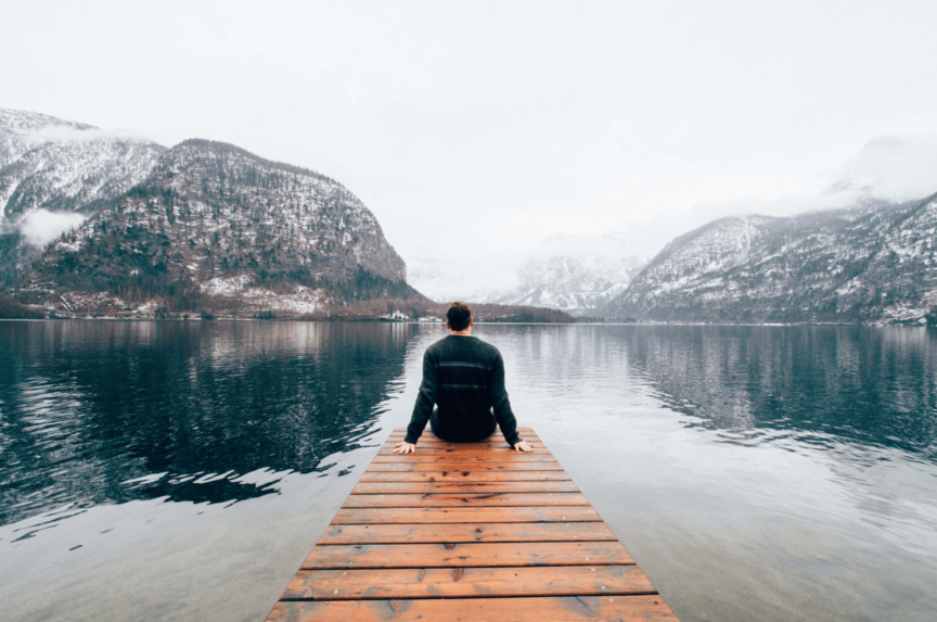 man enjoying nature sitting on a dock