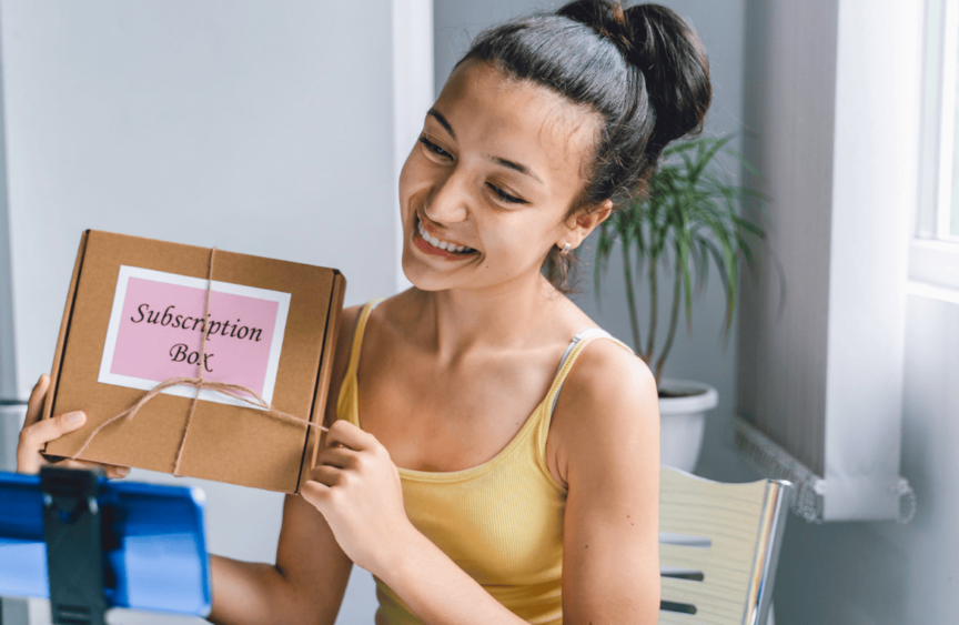 Lady holding a box that says subscription box to promote subscriptions for businesses